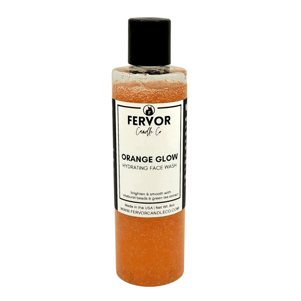 Orange Glow Hydrating Face Wash by Fervor Candle Company. Product design features an orange colored liquid facial cleanser with suspended vitamin-filled bursting beads in a clear 8 ounce cylindrical bottle with black flip-top cap.